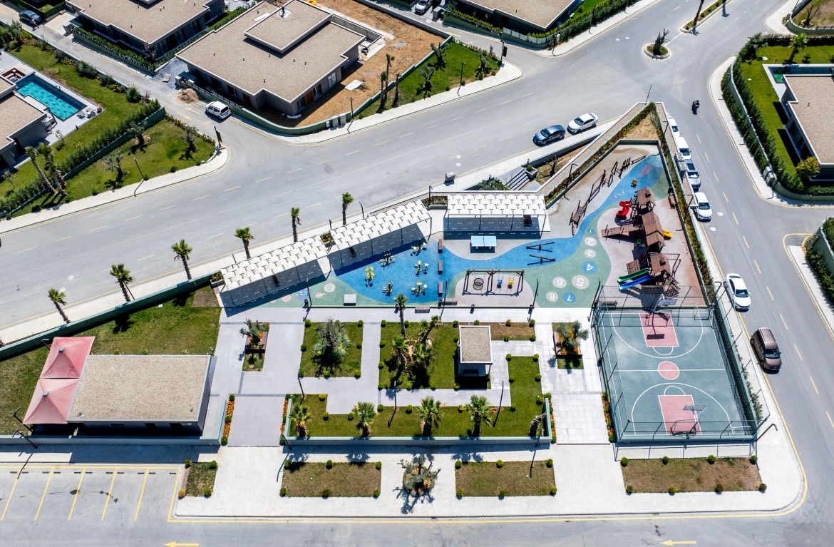 jpg showing the project's dedicated social spaces, including a colorful children's playground, a basketball court, and beautifully landscaped gardens.