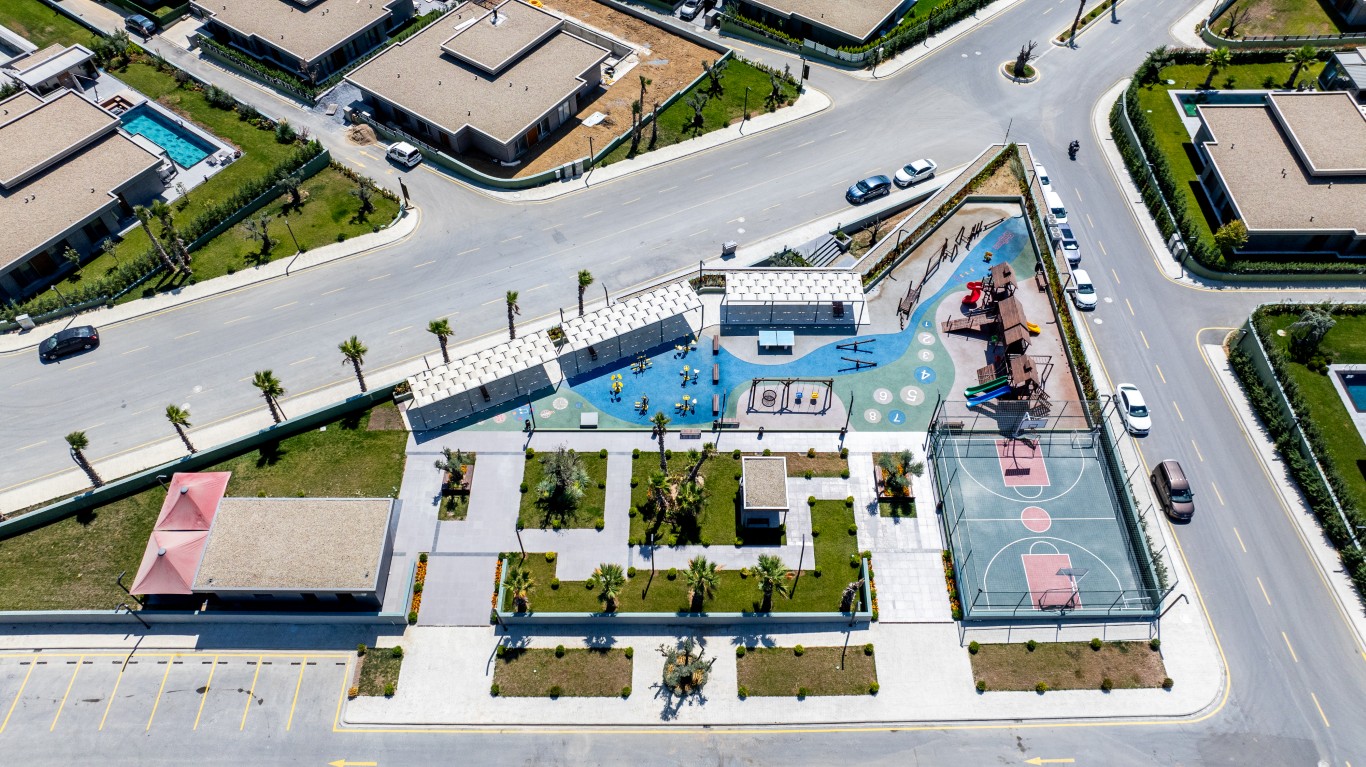 jpg showing the project's dedicated social spaces, including a colorful children's playground, a basketball court, and beautifully landscaped gardens.