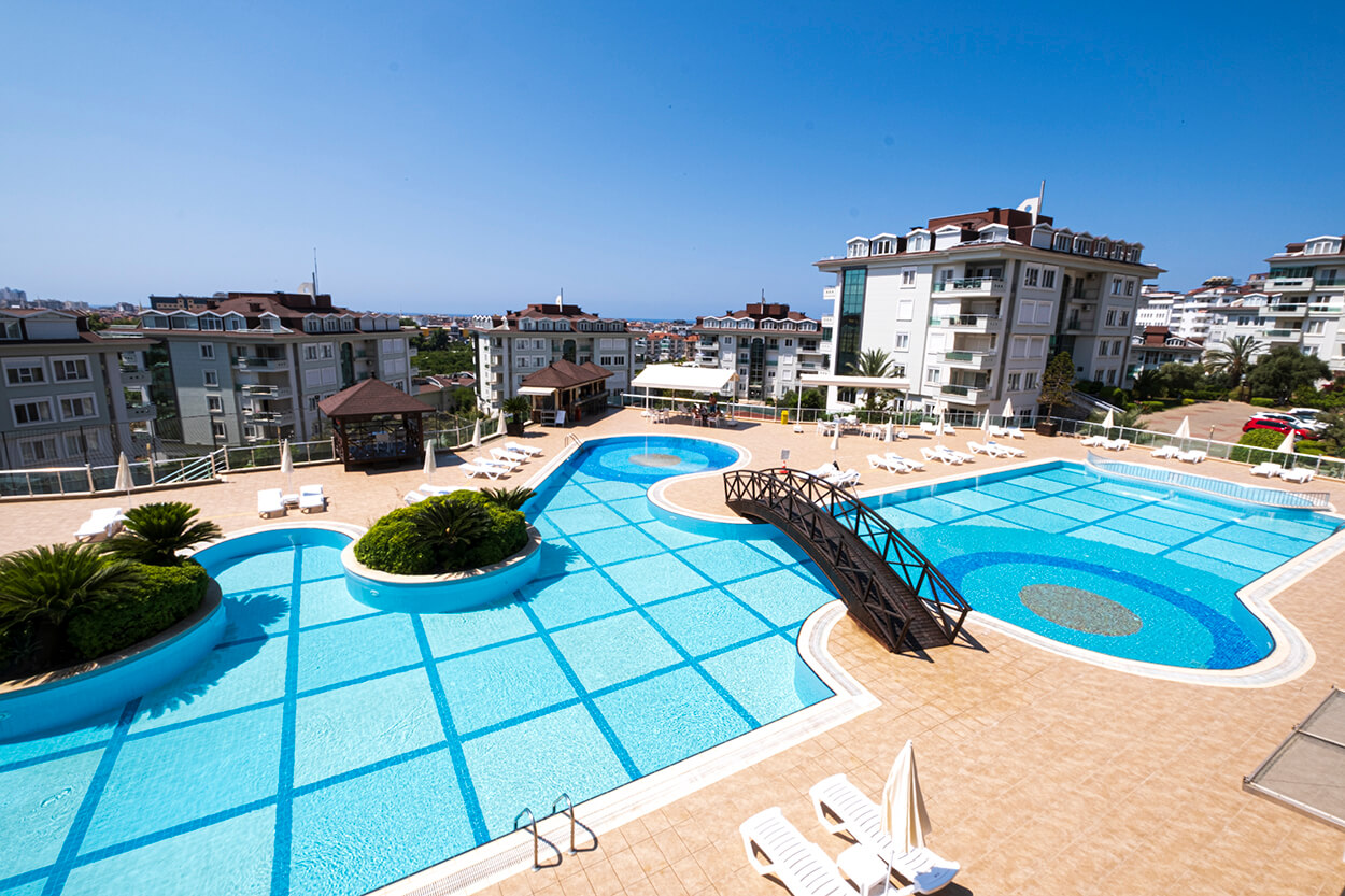 Outdoor swimming pool and residential buildings at Olive City in Oba, Alanya.