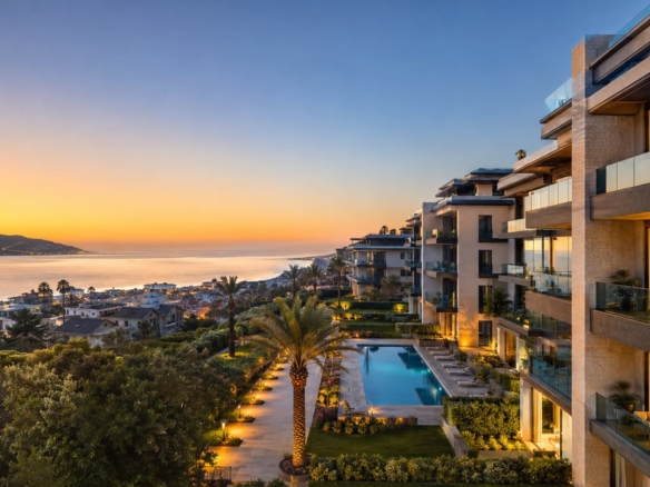 Luxury residential complex with modern architecture illuminated by sunset light on the Mediterranean coast with palm trees.